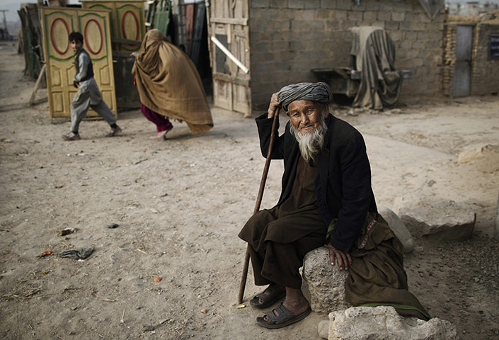 20 Photos: An Afghan refugee sits by the roadside on the outskirts of Islamabad
