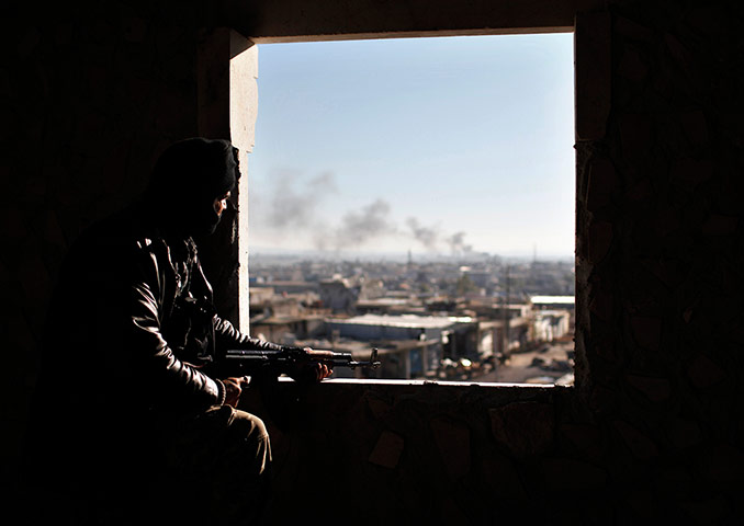 20 Photos: A Free Syria Army fighter views the fighting on the front line in Aleppo
