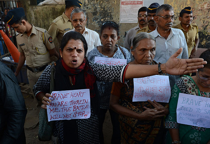 India: An Indian protestor reacts as police officials intervene