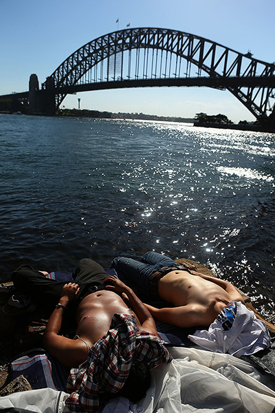24 hours: Sydney, Australia: Men sunbathe before New Year's Eve celebrations