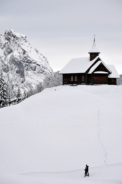 24 hours: Stoos, Switzerland: A couple walks by a church