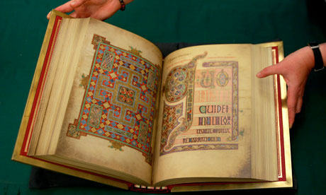 Curator holding the Lindisfarne Gospel