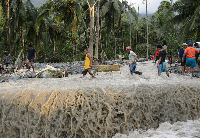 Typhoon Bopha: Residents using a makeshift stretcher carry the dead body