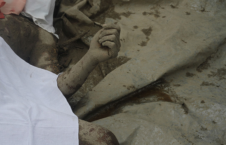 Typhoon Bopha: A victims body is covered as relatives try to identify bodies