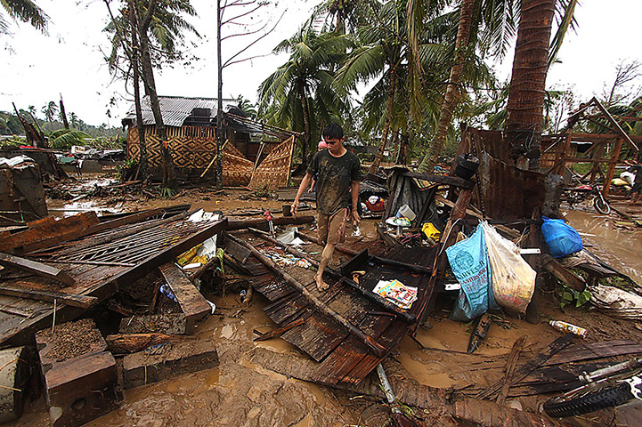 Typhoon Bopha: Residents walk amongst their destroyed houses 