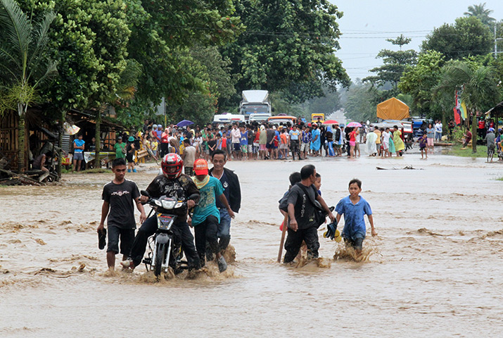 Typhoon Bopha: People cross a flooded road in Mabini