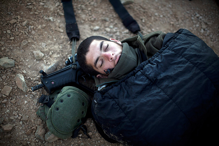 24 hours in pictures: An Israeli Defense Forces (IDF) soldier uses his gun as a pillow