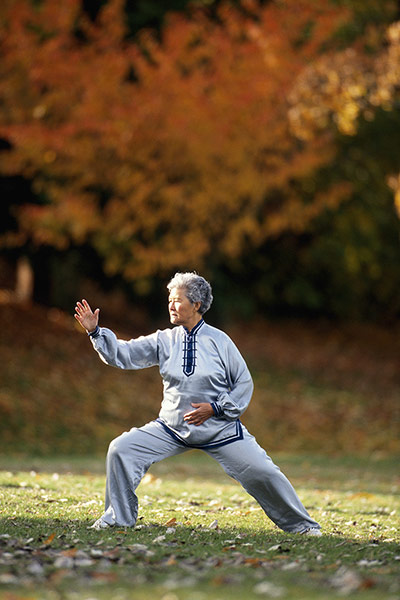 Healthiest cities: Elderly woman tai chi grass