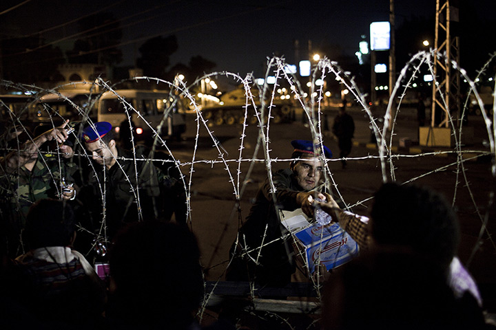 24 hours in pictures: Soldiers of the Egyptian Republican Guard hand out bottles of water to protesters in Cairo