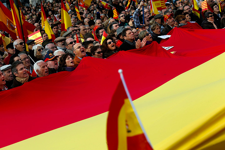 24 hours in pictures: People hold a giant Spanish flag during a rally in Madrid