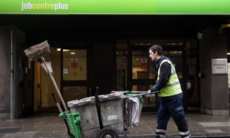 Street cleaner pushes cart past Jobcentreplus building