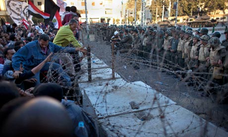 Opponents of Egypt's president Mohamed Morsi try to enter the presidential palace in Cairo