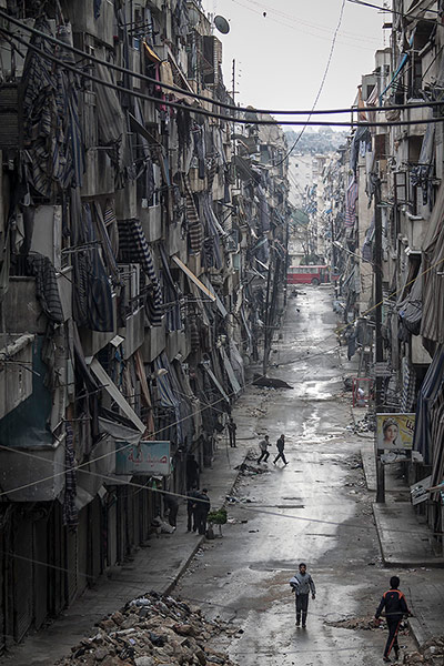 20 Photos: Syrians walk past damaged homes during heavy fighting in Aleppo