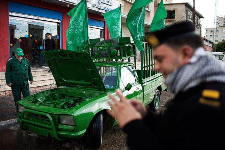 Hamas: A Palestinian Hamas policeman stands next to a vehicle painted green