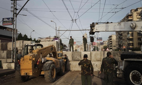 Egyptian army engineers and soldiers build a third line of concrete blocks outside of the Egyptian presidential palace on Sunday.