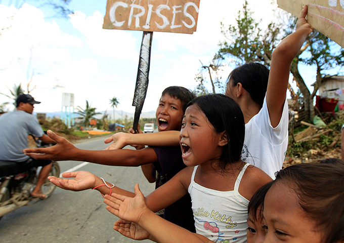 24 hours: Montevista, Philippines: Children beg for food on a street in the typhoon-hit town