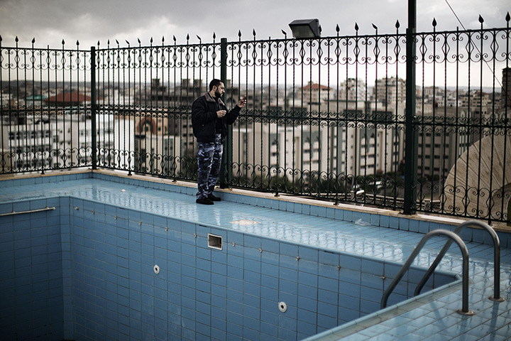 24 hours: Gaza City, Gaza Strip: A police officer takes pictures with his phone from the rooftop of a building