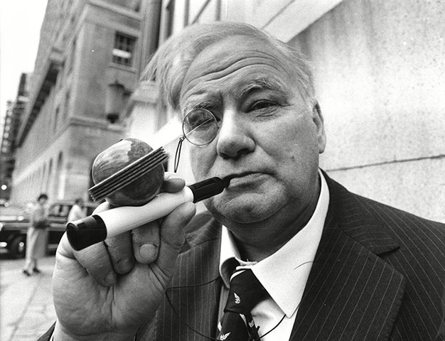 Patrick Moore with a pipe in the shape of a telescope, awarded for 1983 Pipeman of the Year