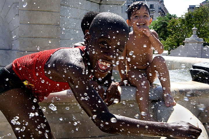 In pictures: splash: Boys playing in water fountain in Havana