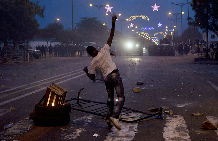 Protest in Senegal: An anti-government demonstrator throws rocks