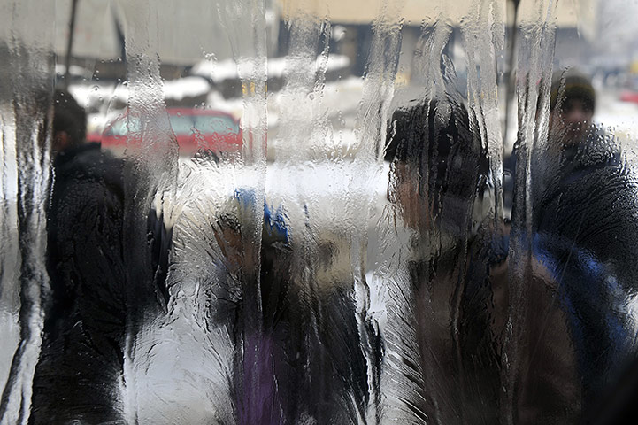 Cold snap continues: Pedestrians viewed through an ice-covered window in Pristina