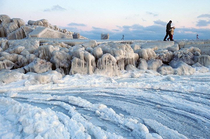 Cold snap continues: People walk on an ice-covered dam next to frozen waters of the Black Sea