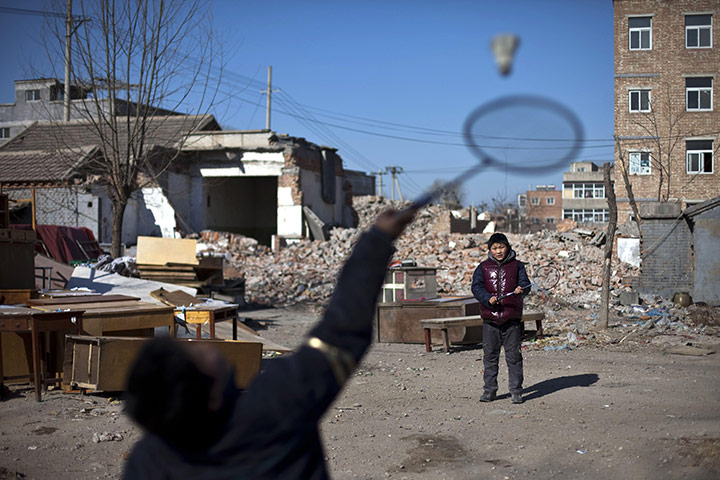 24 hours in pictures: Boys play badminton in a demolished part of Beijing