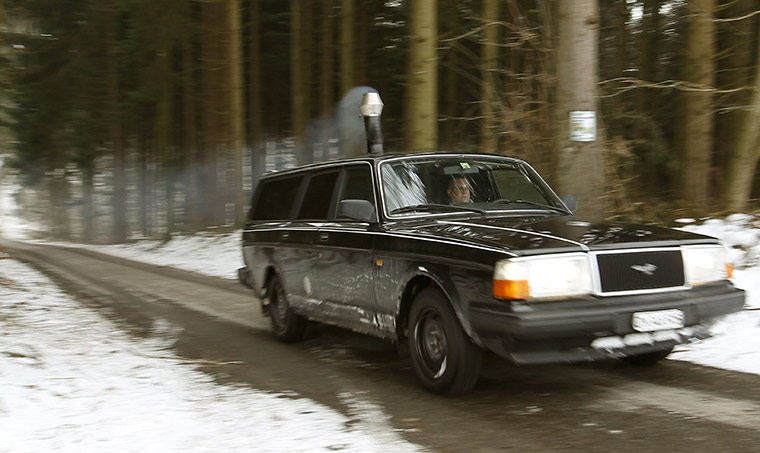 24 hours in pictures: Smoke from a wood stove comes out of a chimney in a  Volvo 240 