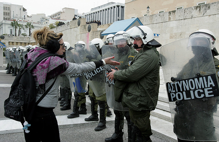 Strikes in Greece: A protester speaks with police in front of the Greek Parliament in Athens