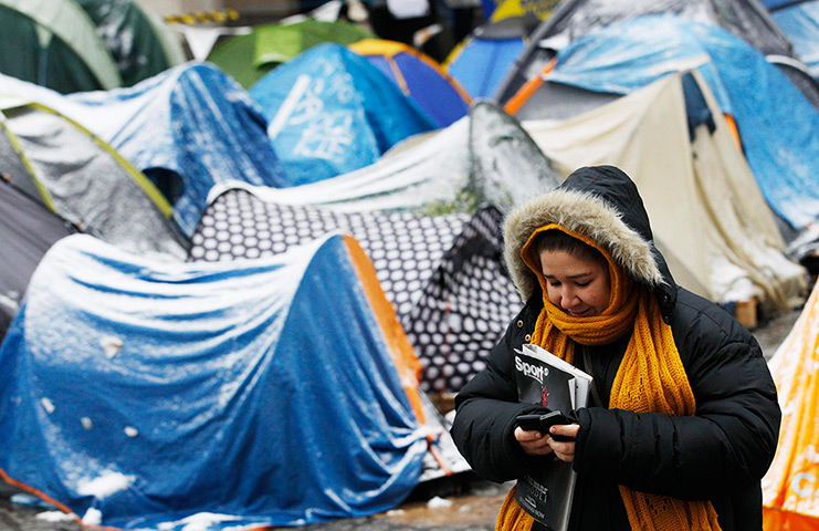 Snow: A pedestrian passes the Occupy London camp outside St Paul's Cathedral