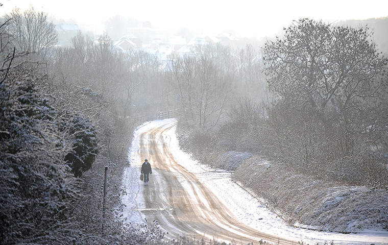 Snow: A woman walks along a snow covered road in Sixfields, Northampton