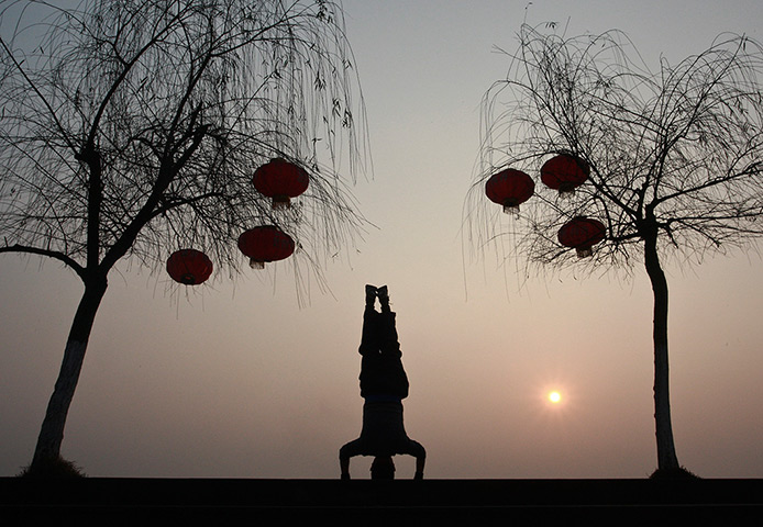 24 hours in pictures: A Chinese man performs morning exercises near a river bank in Suining