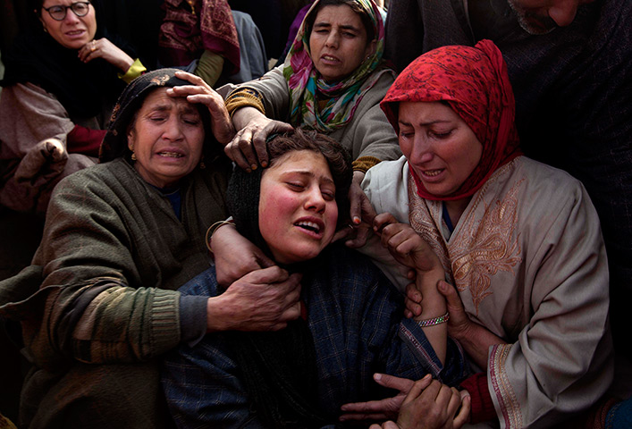 24 hours in pictures: Family comfort a mouner at a funeral procession in India