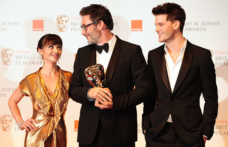 Baftas 2012 winners: Christina Ricci and Jeremy Irvine next to Michel Hazanavicius