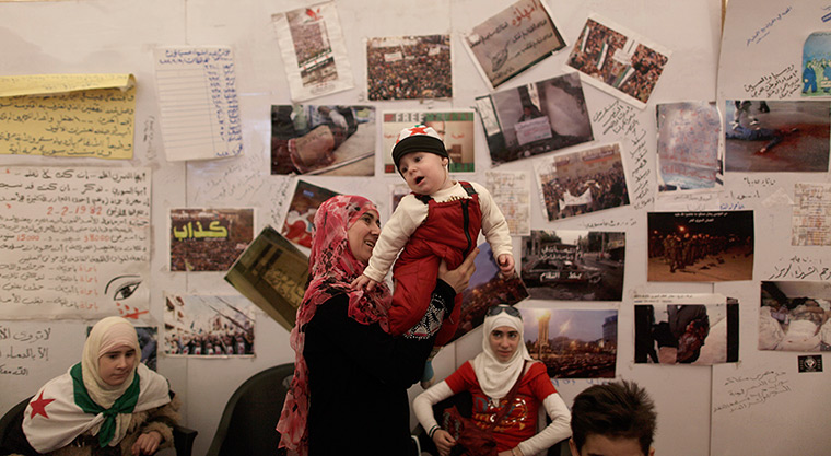 24 hours in pictures: A woman plays with her son inside an anti-Syrian regime protest tent