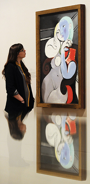 Picasso & Modern Brit Art: An employee poses next to a 1932 painting by Pablo Picasso