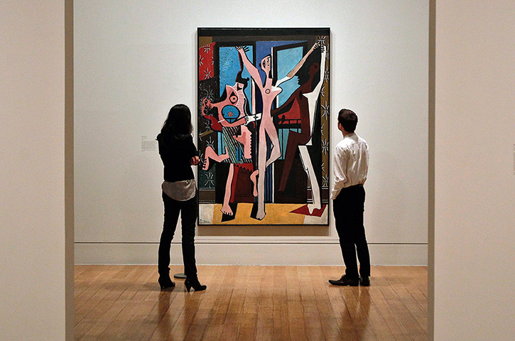 Picasso & Modern Brit Art: Staff members look at Pablo Picasso's painting entitled 'The Three Dancers'