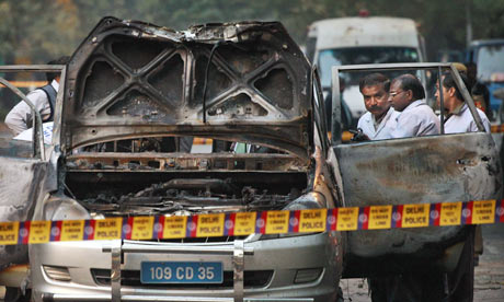 Indian police forensic experts investigate the Israeli embassy car hit by a bomb in New Delhi