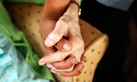 carer holding hands with an elderly person