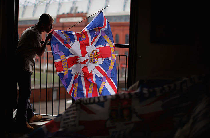 24 hours: Glasgow, Scotland: A man kisses a flag outside his home near Ibrox Stadium