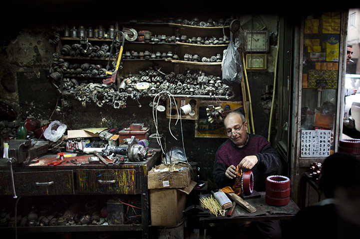 24 hours: Cairo, Egypt: A man wraps copper wire onto a coil in his workshop