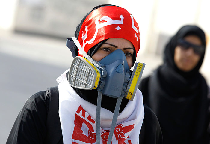Bahrain: An anti-government protester wearing her gas mask