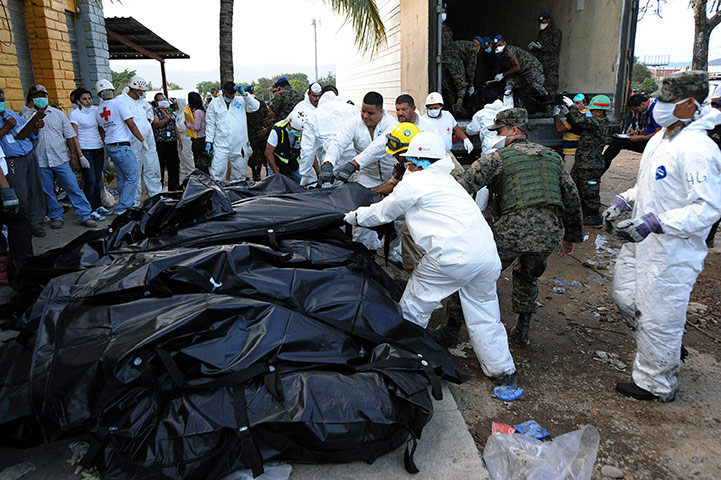 Honduras jail: Honduran forensic workers and soldiers remove corpses in plastic bags