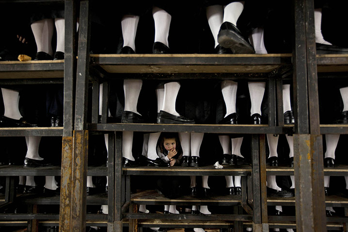 Jewish wedding: A boy looks through the legs of guests