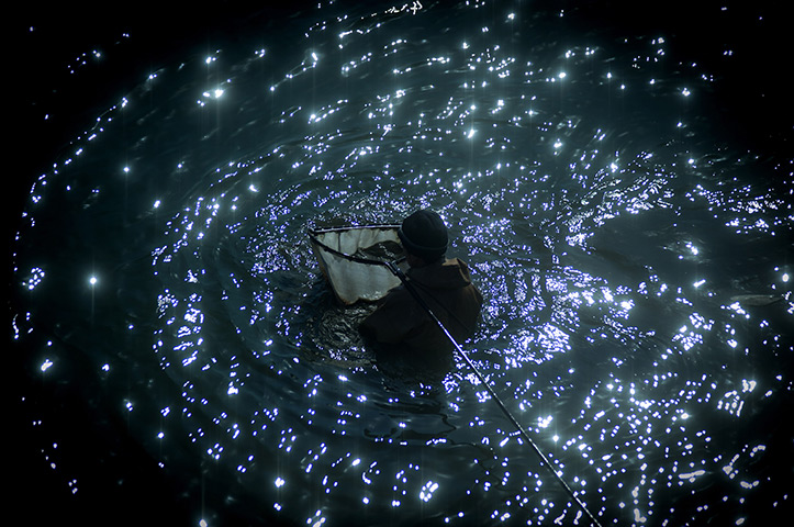 24 hours: Dandong, China: a man catches worms silt in the Yalu River