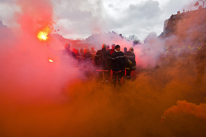 24 hours: Paris, France: Firefighters wave flares as they protest during a strike