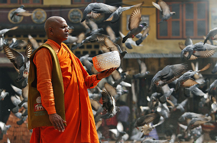 24 hours: Katmandu, Nepal: A Buddhist monk holds a bowl asking for alms