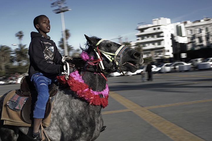 24 hours: Tripoli, Libya: A child rides a horse in Martyrs square 