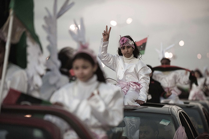 24 hours: Benghazi, Libya: Girls dressed up as angels wave the victory sign