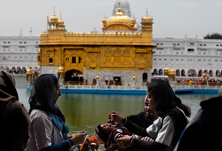 24 hours: Amritsar, India: A child is administered polio drops by health workers